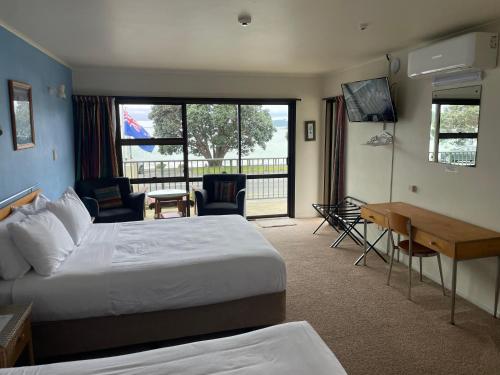 派西亚金沙湾海滨一室公寓的酒店客房设有一张大床和一张书桌。