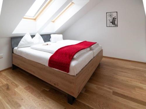 上陶恩Flat in Hohentauern near the ski area的一间卧室配有一张床铺,床上铺有红色毯子