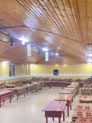 瓦迪拉姆Sunrise Wadi Rum Camp的大型客房配有木桌和椅子。