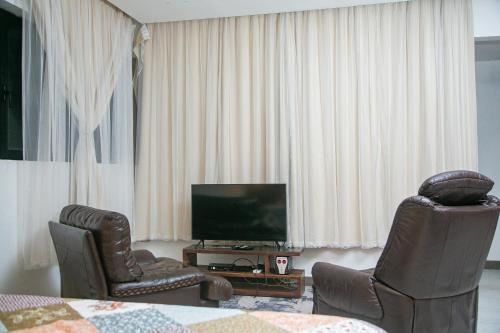 BueaToilcam的客厅配有两把椅子和电视