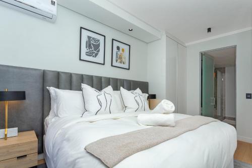 米德兰Luxury Haven at Ellipse Waterfall的卧室配有一张白色大床和灰色床头板