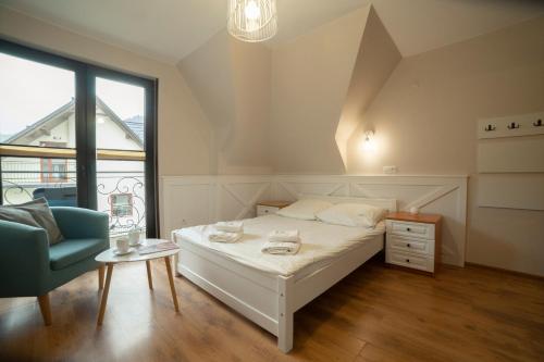 什恰夫尼察Willa Nad Wodospadem的卧室配有床、椅子和窗户。