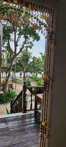 沙美岛Viking Holiday Resort的享有海滩和树木景致的门廊