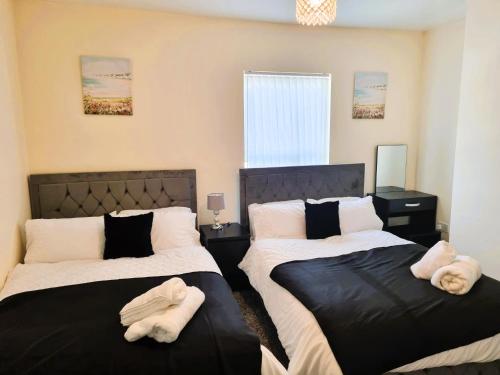 利物浦Luxury house for 6 guests next to Anfield stadium的一间卧室配有两张带毛巾的床