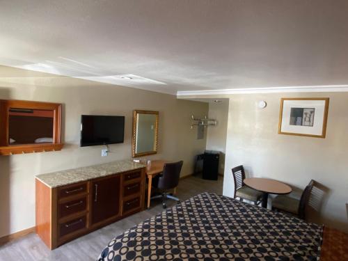 圣贝纳迪诺市中心7号汽车旅馆的酒店客房配有一张床、一张书桌和一台电视。