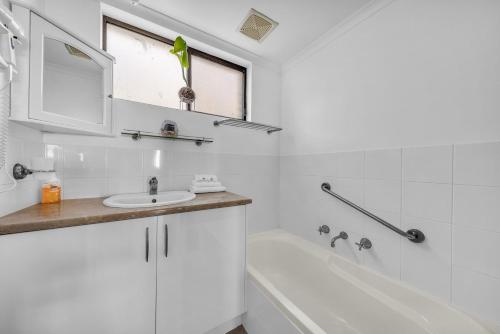 梅林布拉Capri Apartments的白色的浴室设有水槽和浴缸。