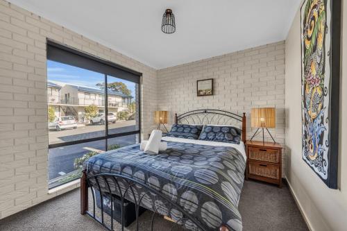 梅林布拉Capri Apartments的一间卧室设有一张床和一个大窗户