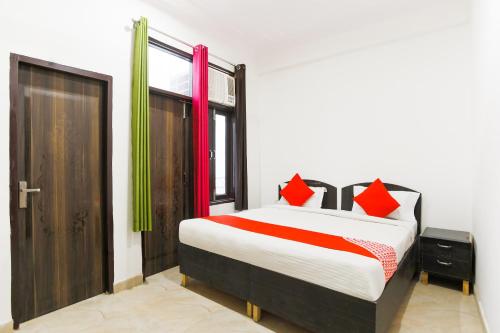 古尔冈OYO Welcome Residency的一间卧室配有一张红色和绿色调的床。
