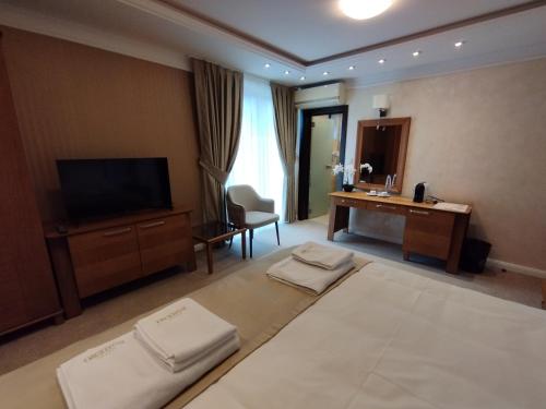 哈斯科沃Hotel Bohemi的酒店客房设有两张床和电视。