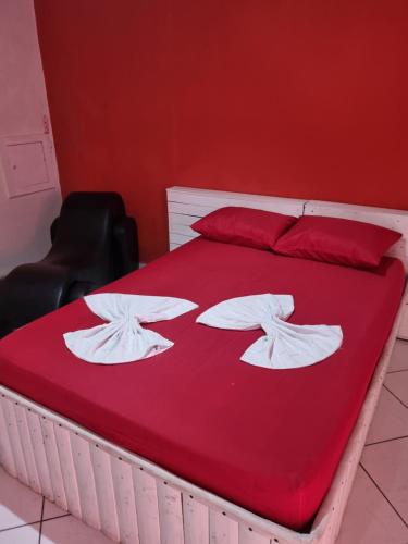 索罗卡巴Pousada Lances De Amor的一张铺有红色床单和白色毛巾的床