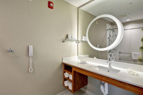 弗洛伦斯辛辛那提机场南春丘套房酒店的一间带镜子和电话的盥洗盆的浴室