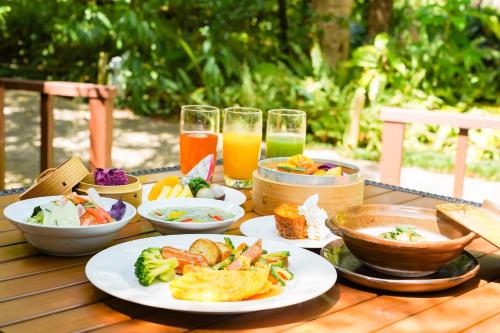 宇流麻冲绳可可花园酒店的餐桌,带食物盘和橙汁杯