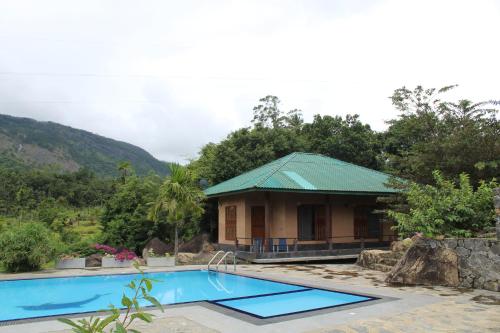 贝里胡罗亚World's End Base Eco-Village的一座带游泳池的度假村,位于一座建筑前