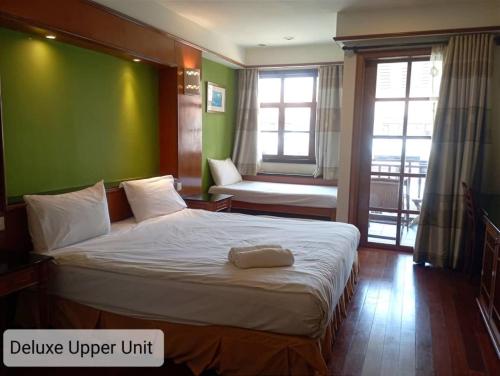波德申Alpine LXPD Water Chalet的一间卧室设有一张大床和绿色的墙壁