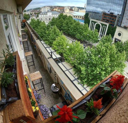普里什蒂纳Prishtina Center Hostel的建筑里种有鲜花和植物的阳台
