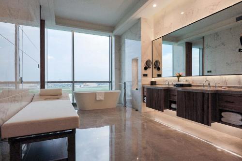 金边VM Hotel的带浴缸和盥洗盆的大浴室