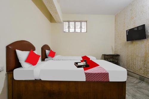 巴特那OYO Vibrant Inn的一间卧室配有两张带红白色枕头的床