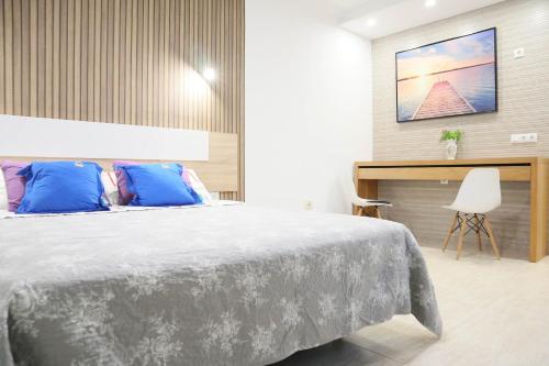 格拉纳迪利亚德亚沃纳HAPPY ROOM的一间卧室配有一张带蓝色枕头的大床