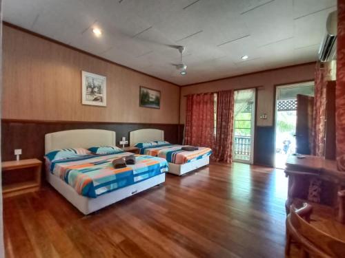 Kampong Pasir HantuMama's Chalet Pulau Perhentian Besar的铺有木地板的客房内的两张床