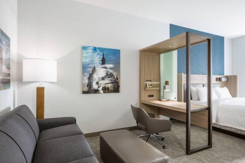 圣保罗SpringHill Suites St. Paul Downtown的酒店客房配有一张床、一张沙发和一张书桌。
