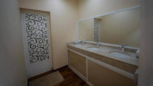 Ḩawīyahاستراحة الكثبان的一间带两个盥洗盆和大镜子的浴室