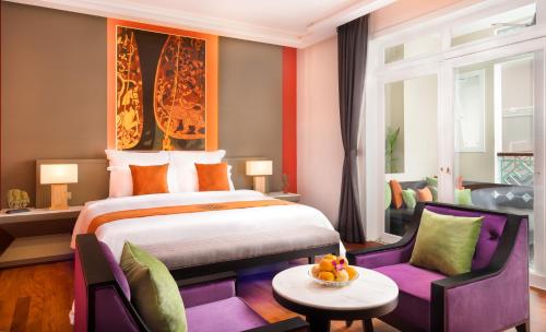 暹粒梅莫瑞度假酒店及Spa的酒店客房带一张床、一张桌子和椅子