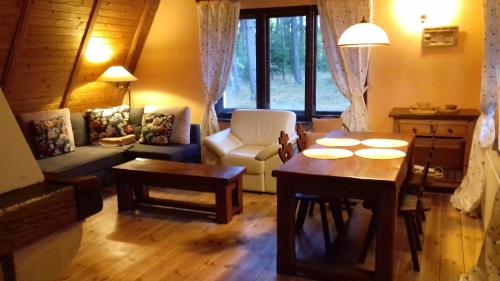 TuszkowyEKOLANDIA domek w lesie na wyłączność的客厅配有桌子和沙发
