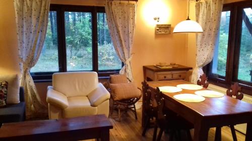 TuszkowyEKOLANDIA domek w lesie na wyłączność的一间带桌椅和窗户的用餐室
