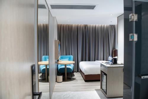 广州上下九城市快捷酒店的酒店客房,配有床和蓝色椅子