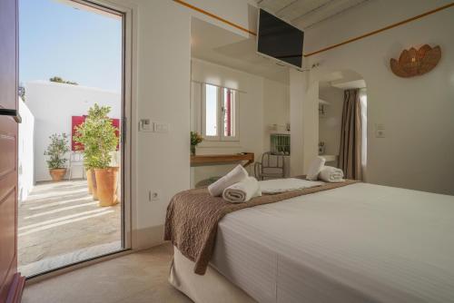 米克诺斯城23 Hotel Mykonos的一间带大床的卧室和一个阳台