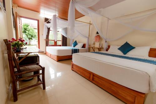宁平Tam Coc Luxury Homestay的一间卧室配有两张床、一张桌子和一张床