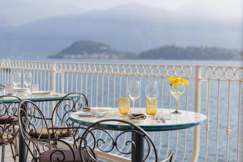 特雷梅佐La Darsena Boutique Hotel & Restaurant的阳台配有桌椅和酒杯