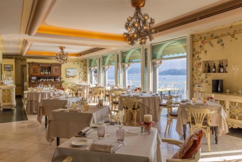 特雷梅佐La Darsena Boutique Hotel & Restaurant的餐厅设有白色的桌椅和窗户。