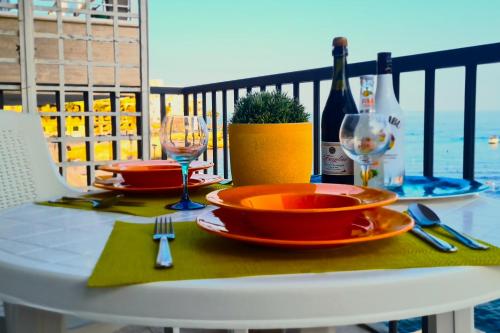 马尔萨斯卡拉Unobstructred seaviews, 2BR, Kingbeds, Fully ACd的阳台上的桌子上摆放着盘子和酒杯
