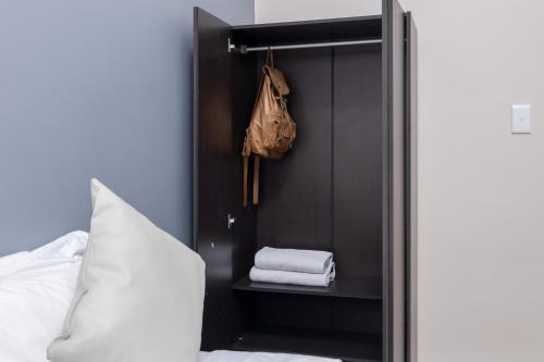 开普敦Cape palm royal guest house的衣柜,配有毛巾、袋子和床
