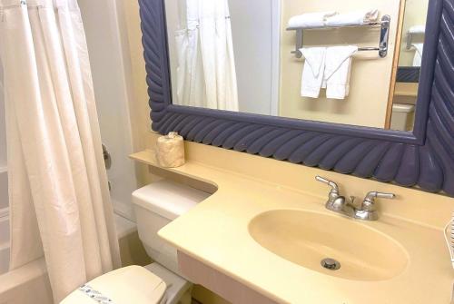 洛杉矶华美达威尔希尔酒店的一间带水槽、镜子和卫生间的浴室