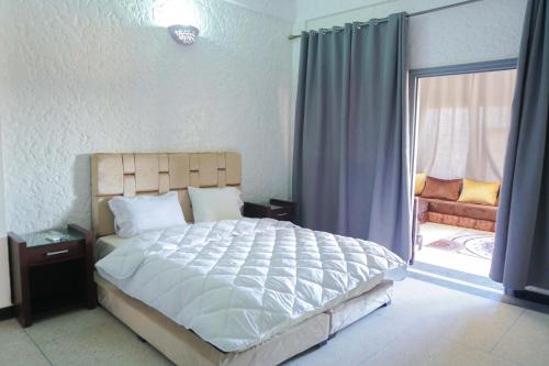 瓦尔扎扎特Hotel Warda的一间卧室设有一张大床和一个滑动玻璃门