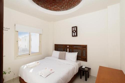 赫尔格达Makadi Heights Elite Residence - Hurghada, Red Sea的卧室设有一张白色大床和一扇窗户。
