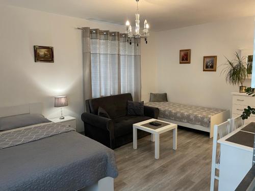 苏瓦乌基NONIEWICZA CENTRUM的一间卧室配有一张床、一把椅子和一张沙发