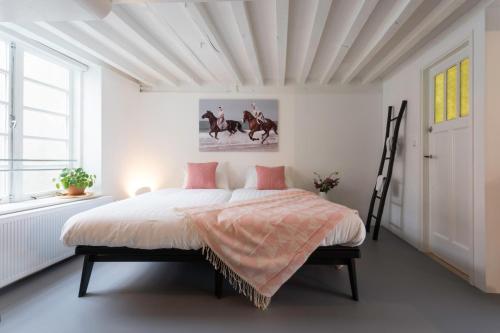 弗利辛恩Hotel Zilt Studio's的一间卧室配有一张粉色和白色床单。