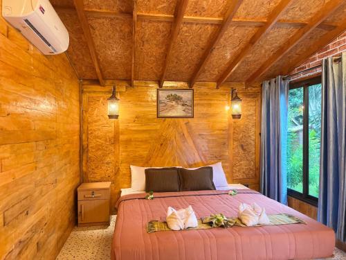 高兰Klong Jark Bungalows的卧室配有木墙内的一张床