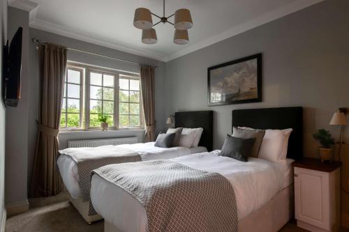 汤布里奇木匠阿姆斯酒店的一间卧室设有两张床和窗户。