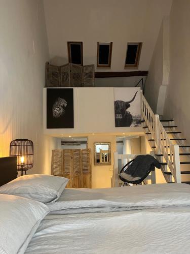 马斯特里赫特Monumentale stadswoning in hartje binnenstad的一间卧室设有一张床和一个楼梯