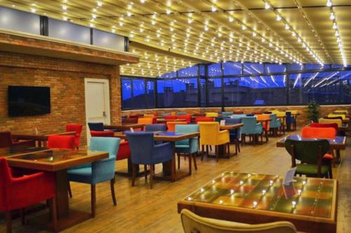萨姆松GRAND DELUX HOTEL的餐厅设有多彩的桌椅和桌面