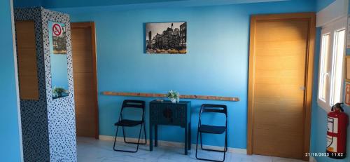 桑坦德Apartamento Zona Playa y centro Ciudad的蓝色的房间,配有一张桌子和两张凳子