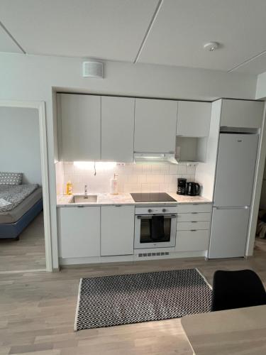 万塔New built One bedroom Apartment nearby Train station的厨房配有白色橱柜和炉灶烤箱。