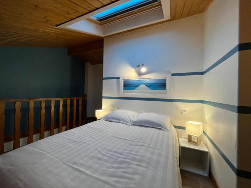 索恩河畔自由城Le Caladois的一间卧室配有一张蓝色和白色墙壁的床
