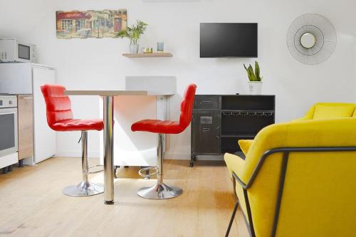 圣阿韦尔坦Gîte le Saint-Honoré的厨房配有桌子和2把红色椅子