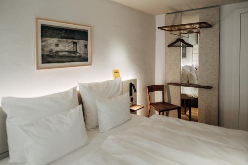 安贝格Bootshaus Amberg的卧室配有白色的床铺和白色的枕头