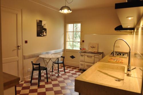 拉布雷德Le Pavillon du Lac的厨房配有柜台和桌椅